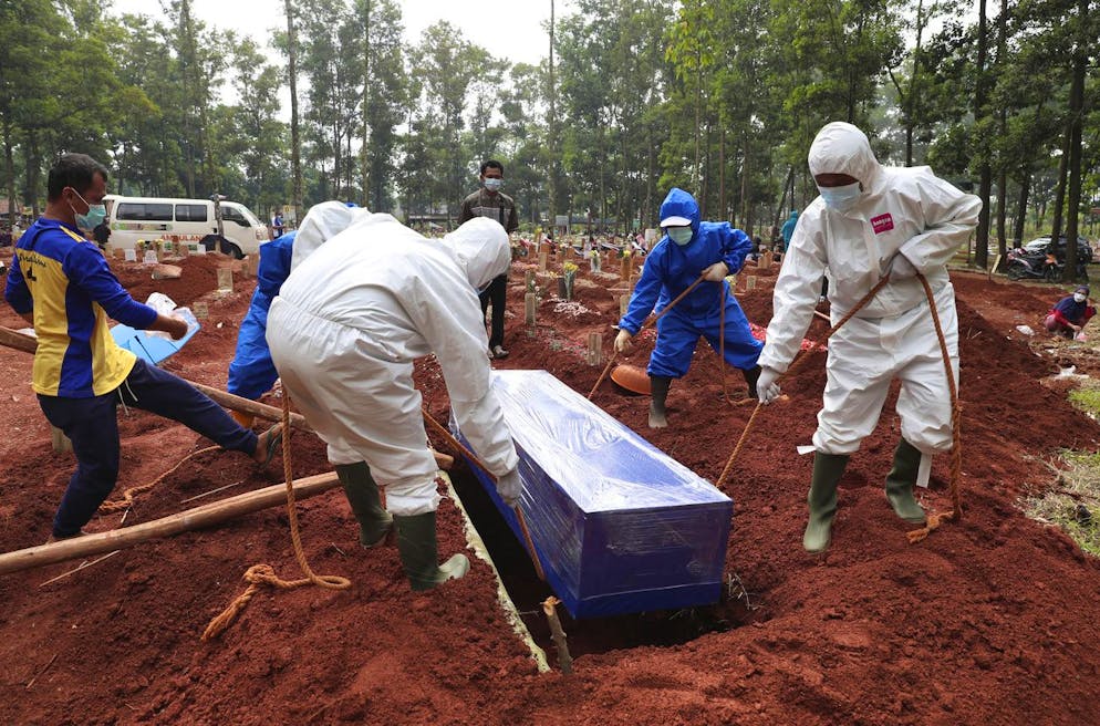 Workers in protective suits lower a coffin containing the body of a COVID-19 victim into a grave during a burial at Cipenjo cemetery in Bogor, West Java, Indonesia on July 14, 2021. With the numbers of death increasing from the latest virus surge in Indonesia which has crippled the healthcare system in Java and Bali, relatives and residents decided to volunteer to dig graves using their own hoes and shovels to help exhausting gravediggers. (AP Photo/Achmad Ibrahim)