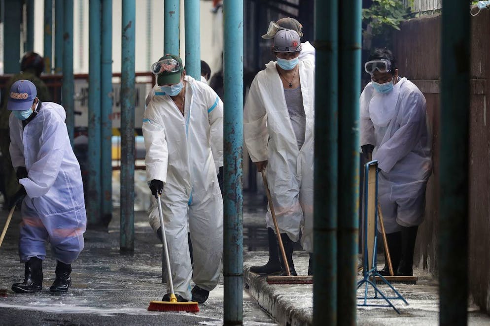 Des travailleurs portant des combinaisons de protection désinfectent un marché public pour aider à empêcher la propagation du coronavirus dans la ville de Marikina, aux Philippines. (archives)