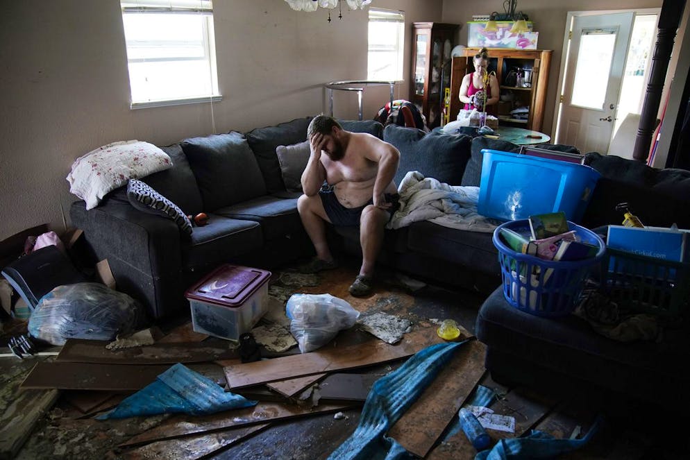 Josh Montford repose sa tête dans sa main tout en traversant sa maison endommagée par les inondations à la suite de l'ouragan Ida.