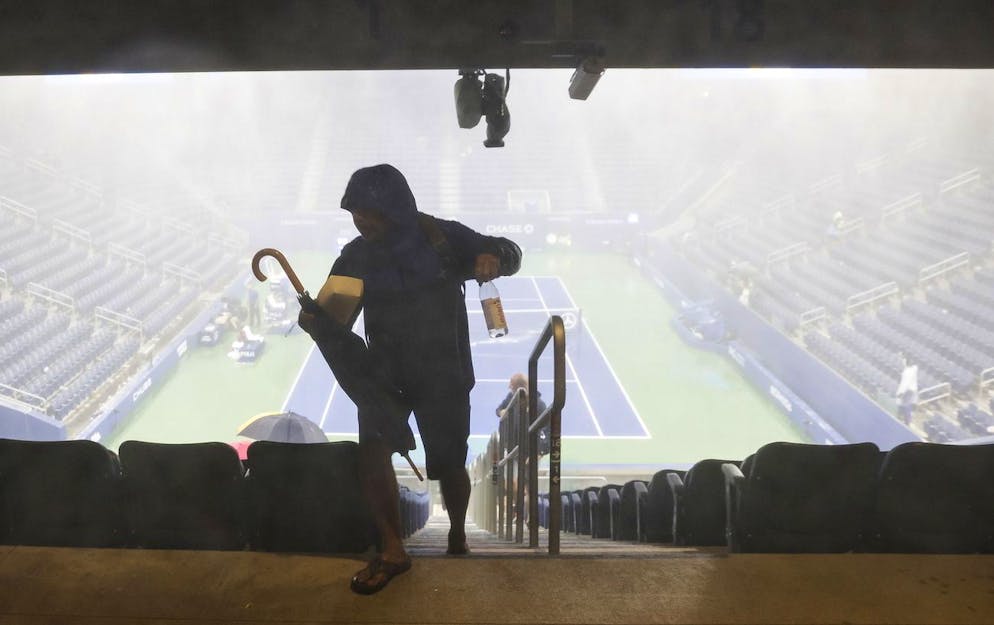 Une personne sort du Louis Armstrong, principalement couvert, alors que de fortes pluies soufflent sur le côté du Billie Jean King National Tennis Center alors que les restes de l'ouragan Ida frappent la région de Flushing Meadows.
