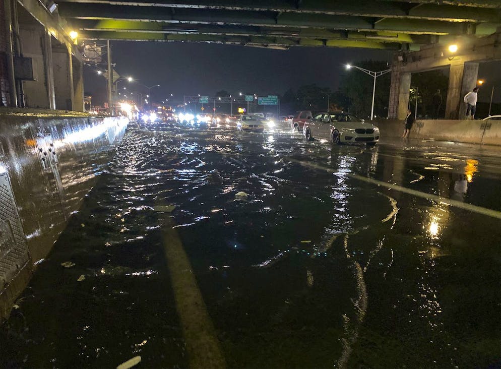 Les gens sont vus debout sous un passage souterrain alors que leurs voitures sont bloquées sur la Long Island Expressway en raison d'inondations causées par une averse massive de pluie de l'ouragan Ida dans le Queens Borough de New York.