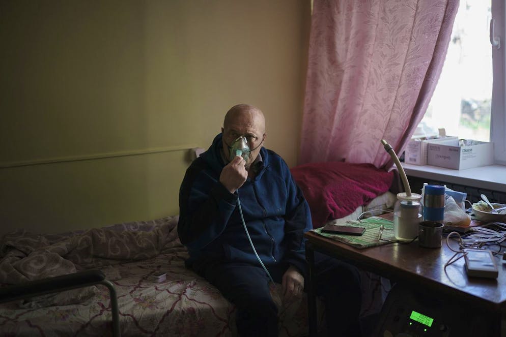 Un patient COVID-19 respire à l'aide d'un masque à oxygène dans un hôpital de la ville de première ligne de Krasnohorivka, près de Donetsk, en Ukraine, le mercredi 5 mai 2021.