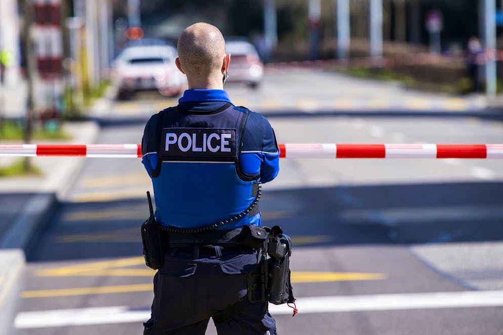 Un policier patrouille autour du gymnase de Beaulieu apres une alerte a la bombe le mercredi 24 mars 2021 a Lausanne. (KEYSTONE/Jean-Christophe Bott)