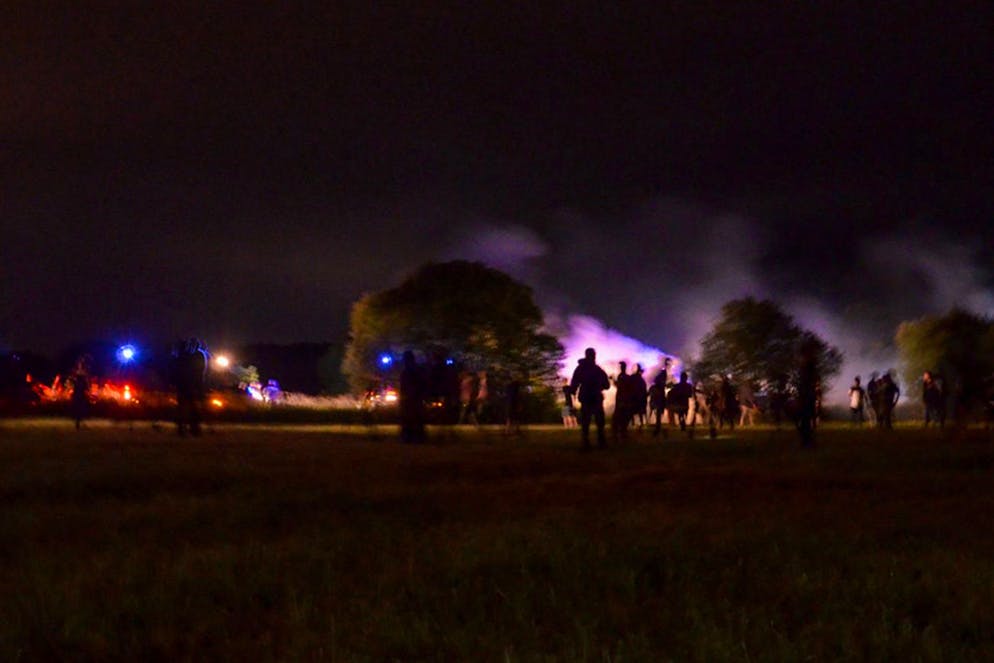 Youths stand in a field during clashes as police tried to break up an unauthorized rave party near Redon, Brittany, Friday June 18, 2021. Police repeatedly fired tear gas and charged clusters of violent partiers who hurled metal balls, gasoline bombs and other projectiles at security forces, according to images of the clashes shared online and the top government official in the region. Local authorities estimated about 1,500 people took part despite a local ordinance banning the event. (AP Photo)