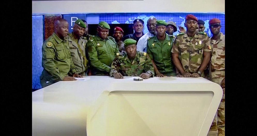 In this image made from video, an unnamed military officer identifying himself as the spokesperson of the National Committee for Rally and Development (CNRD), surrounded by others, makes an address to the nation from state television headquarters in the capital Conakry, Guinea Sunday, Sept. 5, 2021. Mutinous soldiers in the West African nation detained President Alpha Conde on Sunday after hours of heavy gunfire rang out near the presidential palace in the capital, then announced on state television that the government had been dissolved in an apparent coup d'etat. (Radio Television Guineenne via AP)