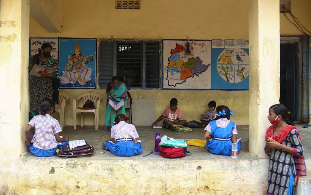School children wearing face masks as a precaution against the coronavirus attend a class on the first day of partial reopening of government schools in Hyderabad, India, Wednesday, Sept. 1, 2021. More students in India will be able to step inside a classroom for the first time in nearly 18 months Wednesday, as authorities have given the green light to partially reopen more schools despite apprehension from some parents and signs that infections are picking up again. Schools and colleges in at least six more states will reopen in a gradual manner with health measures in place throughout September. (AP Photo/Mahesh Kumar A.)