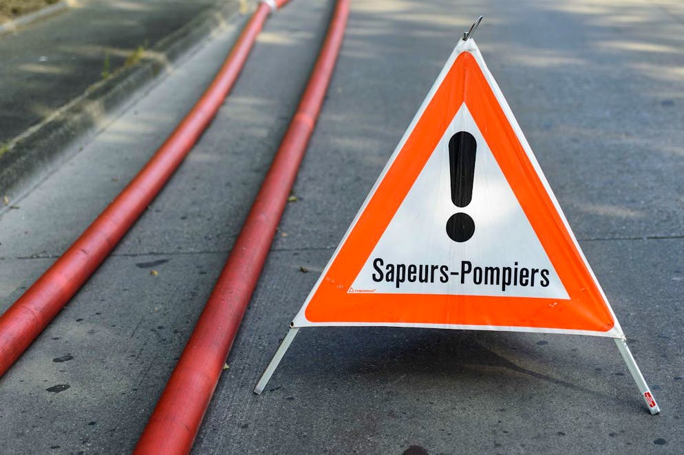 Un panneau avertissement signale que des pompiers du SIS (Service d'Incendie et de Secours) s'affairent sur un incendie ou un accident, photographie, ce dimanche 19 juillet 2015 a Geneve. (KEYSTONE/Martial Trezzini)
