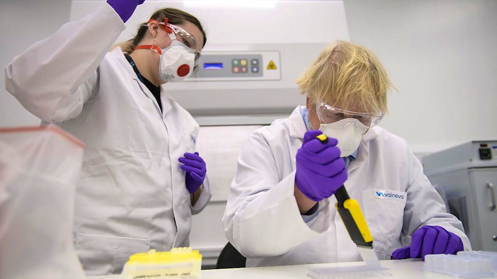 ARCHIV - Großbritanniens Premierminister Boris Johnson besichtigt das französische Biotech-Unternehmen Valneva. Gut ein halbes Jahr nach Vertragsabschluss mit dem Corona-Impfstoffentwickler Valneva hat die britische Regierung den Vertrag über die Lieferung von 100 Millionen Dosen gekündigt. Foto: Wattie Cheung/Daily Mail/PA Wire/dpa