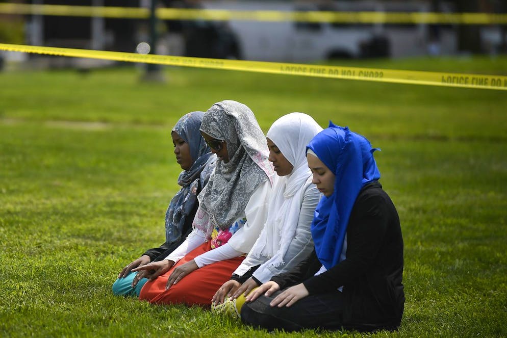 FILE - In this Saturday Aug. 5, 2017 file photo, a group of women take part in afternoon prayers led by Dar Al Farooq Islamic Center Executive Director Mohamed Omar outside the police tape surrounding the center, in Bloomington, Minn. The leader of an Illinois anti-government militia group who authorities say masterminded the 2017 bombing of a Minnesota mosque is to be sentenced Monday, Sept. 13, 2021, for several civil rights and hate crimes in an attack that terrified a community. (Aaron Lavinsky/Star Tribune via AP, File)