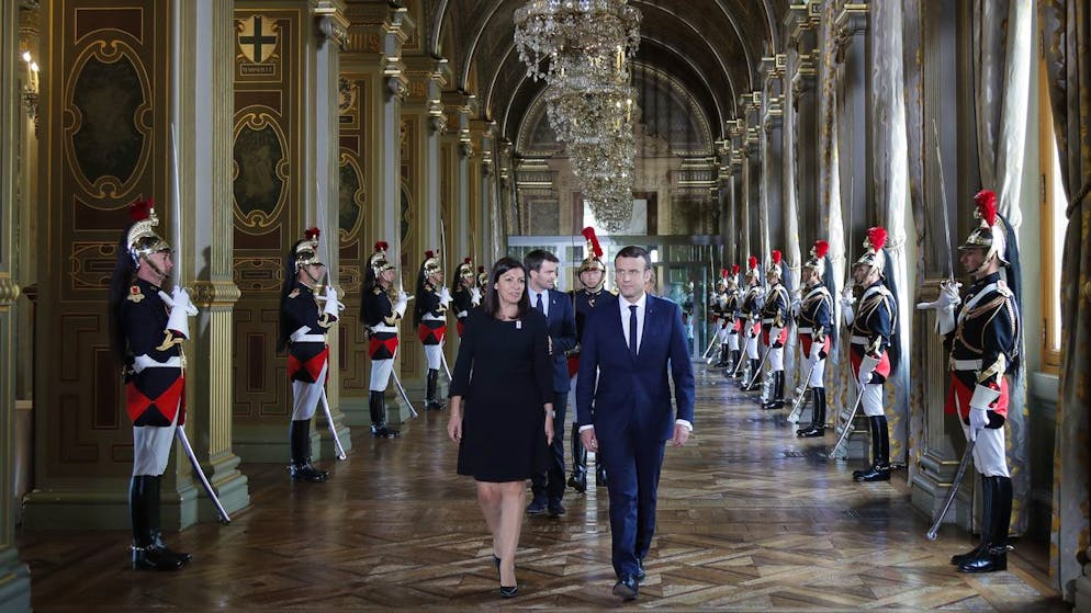 French President Emmanuel Macron and Paris Mayor Anne Hidalgo, left, walk together to attend a ceremony at the Paris city hall, France, Sunday, May 14, 2017. (Charles Platiau/Pool Photo via AP)