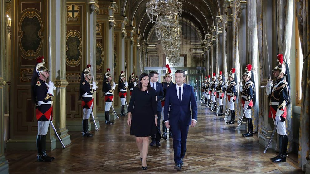 French President Emmanuel Macron and Paris Mayor Anne Hidalgo, left, walk together to attend a ceremony at the Paris city hall, France, Sunday, May 14, 2017. (Charles Platiau/Pool Photo via AP)