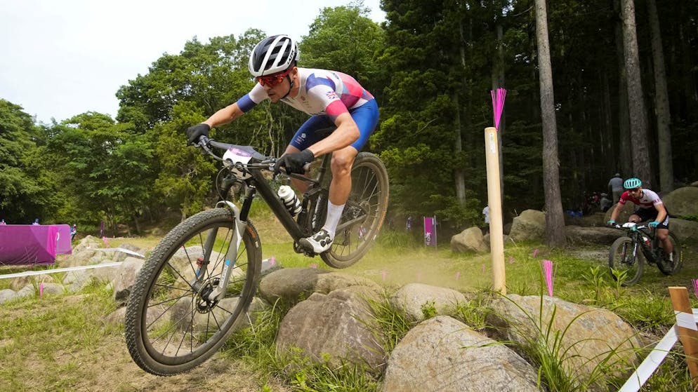 Thomas Pidcock of Great Britain (29) and Nino Schurter of Switzerland (1) compete during the men's cross country mountain bike competition at the 2020 Summer Olympics, Monday, July 26, 2021, in Izu, Japan. (AP Photo/Christophe Ena)