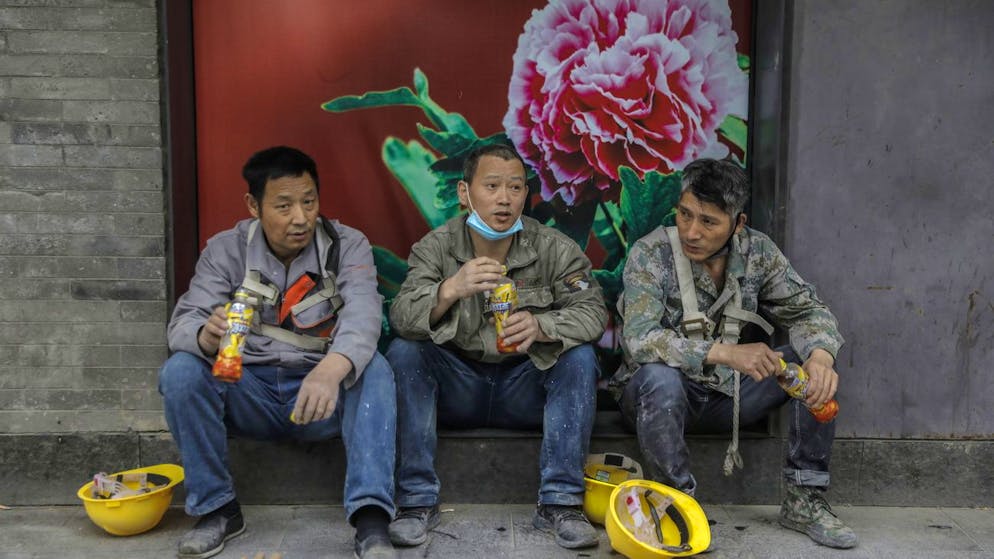 epa08409244 Three migrant workers rest at Qianmen commercial street in Beijing, China, 08 May 2020. The nationwide lockdown during the coronavirus pandemic has caused unemployment, contraction of China's economy and tension between China and the US, which could possibly effect trade negotiations between the two nations. EPA/WU HONG