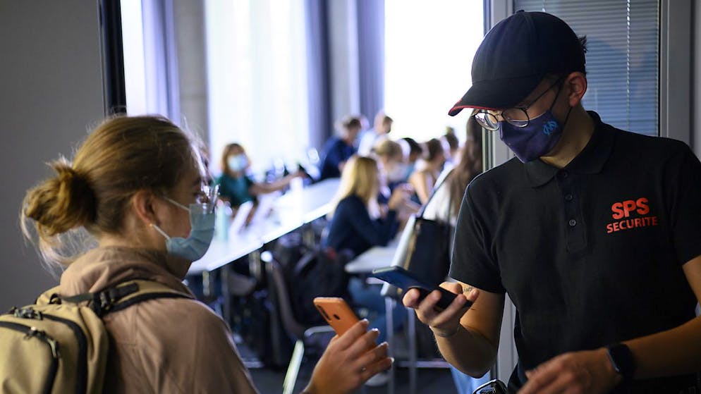 Le personnel de sécurité contrôle le certificat Covid d'une étudiante le jour de la rentrée universitaire mardi à l'Université de Lausanne.
