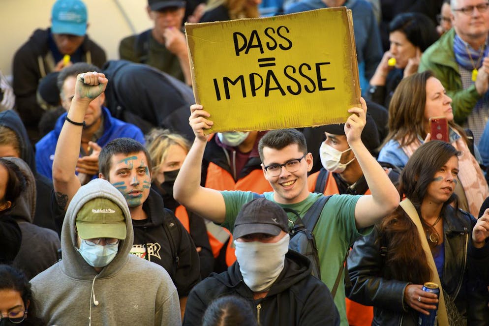 Des personnes brandissent des pancartes sur la place de la Riponne lors d'une manifestation contre l'obligation du certificat covid ce mardi 21 septembre 2021 à Lausanne. (archives) L'accès aux activités doit rester garanti jusqu'à l'âge de 25 ans sans obligation de présenter un certificat, estime l'Association faîtière suisse pour l'animation socioculturelle enfance et jeunesse.