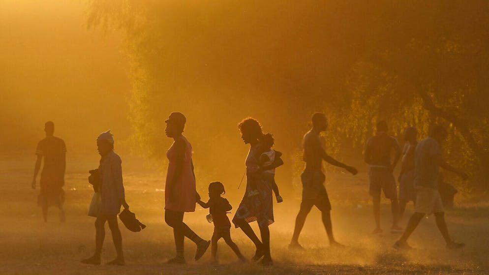dpatopbilder - Migranten, viele von ihnen aus Haiti, gehen zu einem improvisierten Flüchtlingslager in Ciudad Acuña. Die USA fliegen Haitianer, die in einer texanischen Grenzstadt kampieren, zurück in ihr Heimatland und hindern andere am Grenzübertritt aus Mexiko. Foto: Fernando Llano/AP/dpa