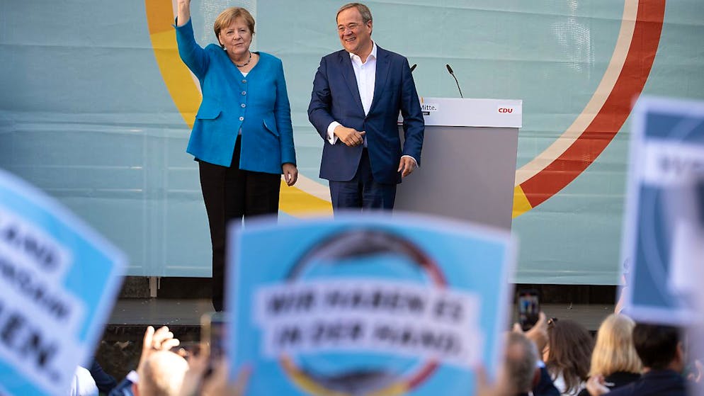 Bundeskanzlerin Angela Merkel und Armin Laschet, Ministerpräsident von Nordrhein-Westfalen, Bundesvorsitzender der CDU und Spitzenkandidat seiner Partei, stehen bei einem gemeinsamen Wahlkampfauftritt auf der Bühne. Foto: Federico Gambarini/dpa