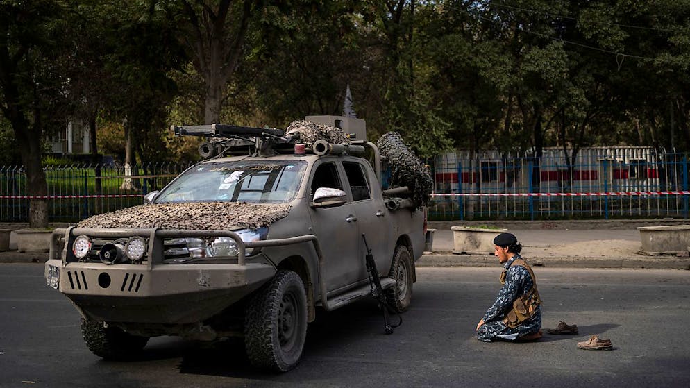Ein Kämpfer der Taliban betet auf der Strasse neben einer von der afghanischen Gesellschaft der muslimischen Jugend organisierten Demonstration, bei der die Freigabe von eingefrorenen internationalen Geldern gefordert wird. Foto: Bernat Armangue/AP/dpa
