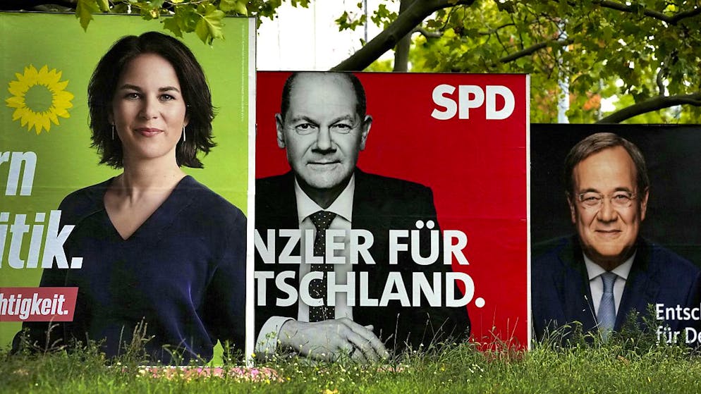 Le SPD d'Olaf Scholz (affiche du centre) devance légèrement, avec 25%, la CDU d'Armin Laschet (affiche de droite), créditée de 22 à 23% et les Verts d'Annalena Baerbock (17%).