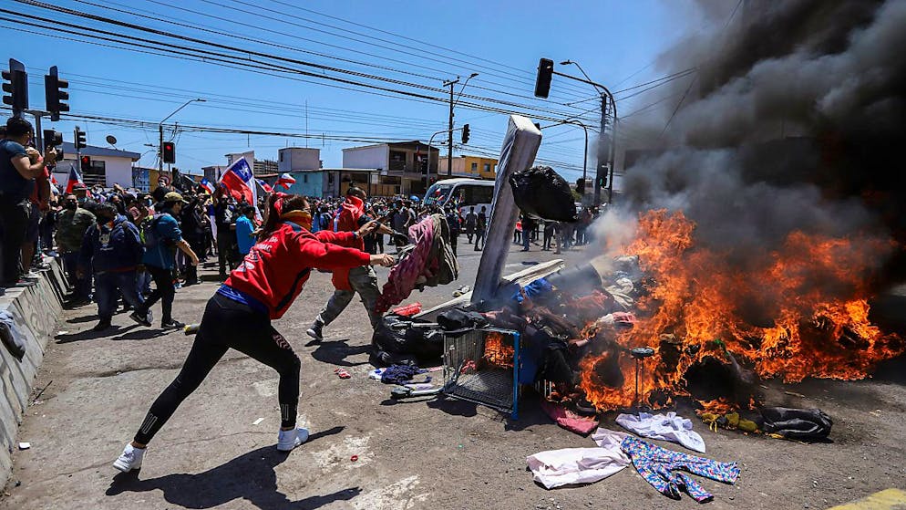 Menschen verbrennen Zelte und Gegenstände venezolanischer und kolumbianischer Migranten während einer Demonstration gegen illegale Einwanderung. Foto: Ignacio Muñoz/AP/dpa