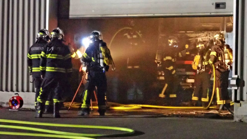 Feuerwehrleute löschen den brennenden Lastwagen in einer Werkstatt in Tägerwilen TG.