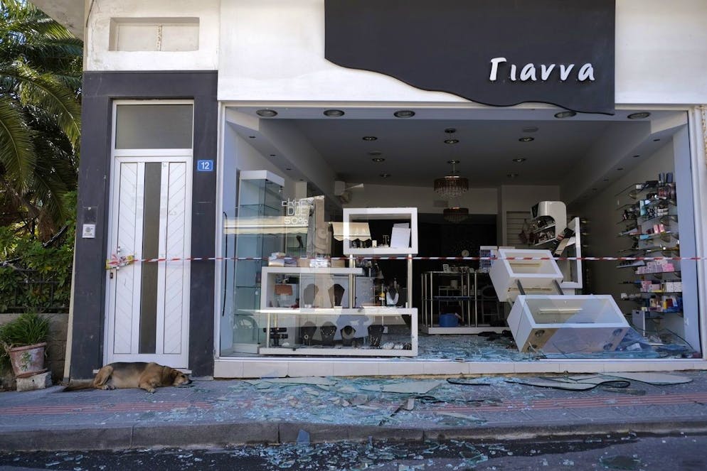 Un chien se trouve à côté d'un magasin endommagé après un violent tremblement de terre dans le village d'Arkalochori sur l'île méridionale de Crète, en Grèce, le lundi 27 septembre 2021.