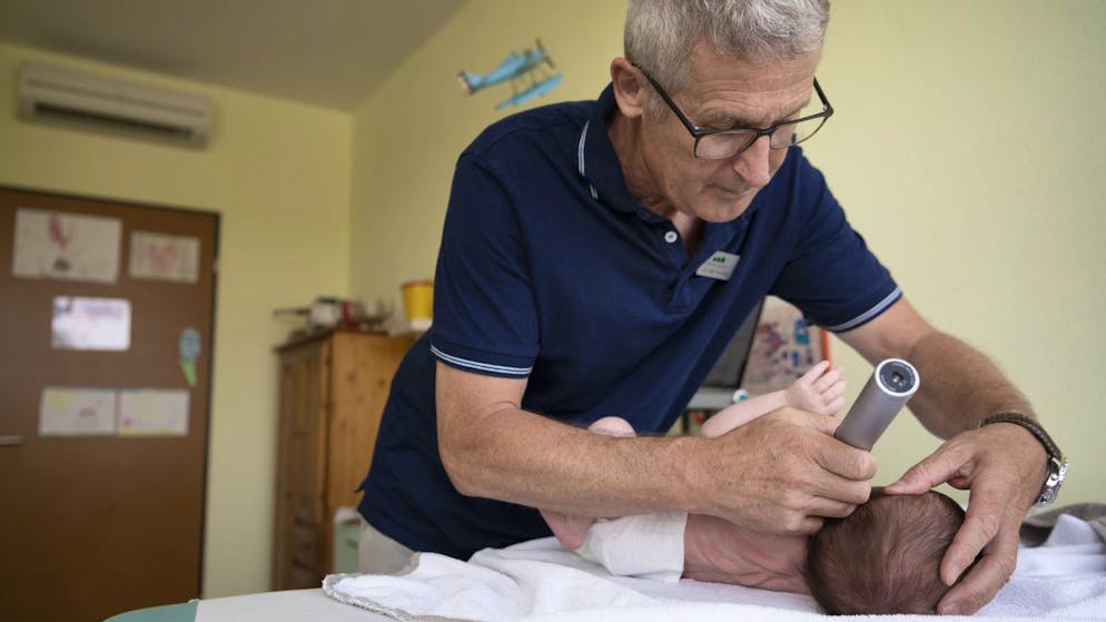 Ein Kinderarzt untersucht einen Säugling in Baar ZG: Auf dem Land leben sie meistens gesünder.
