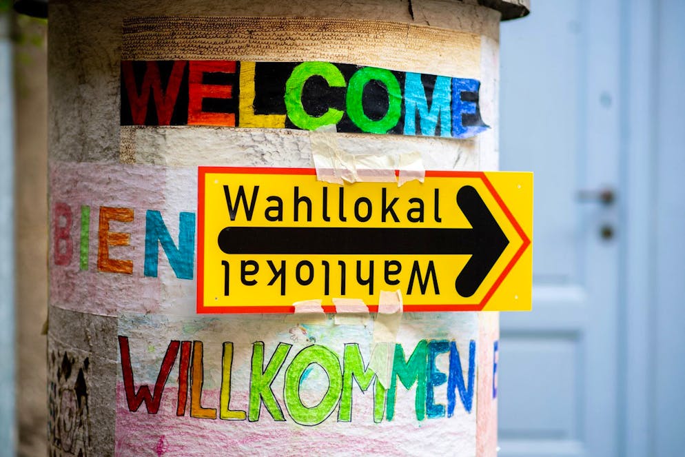 Ein Schild weist im Berliner Stadtteil Prenzlauer Berg den Weg zu einem Wahllokal.