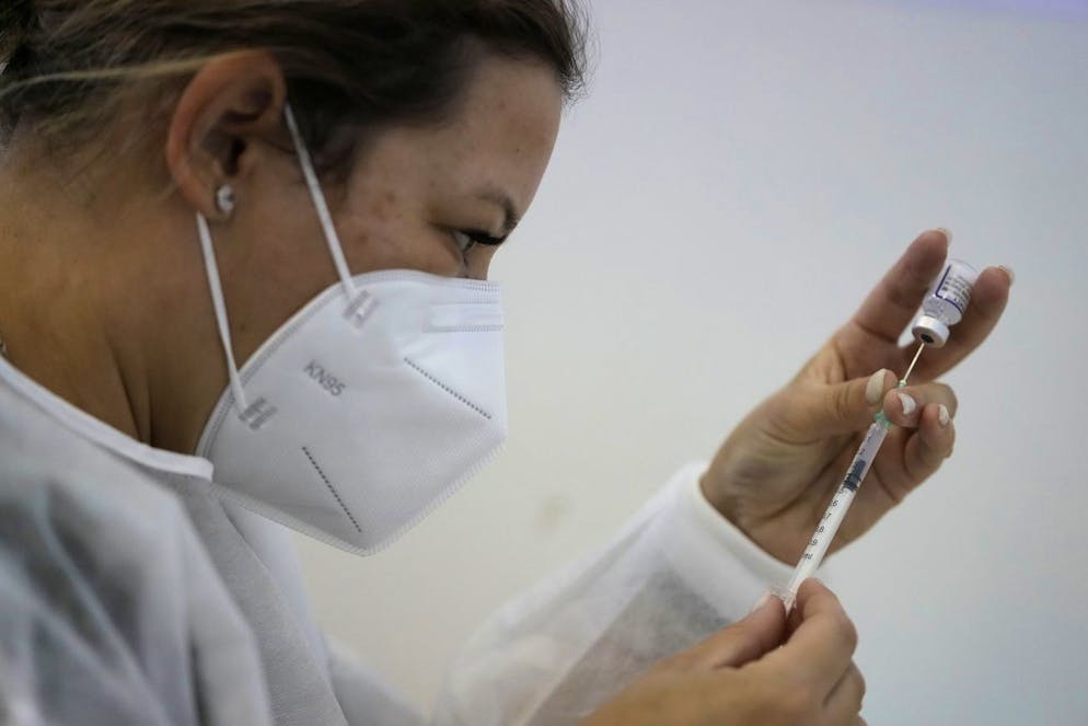 Une infirmière prépare une dose du vaccin