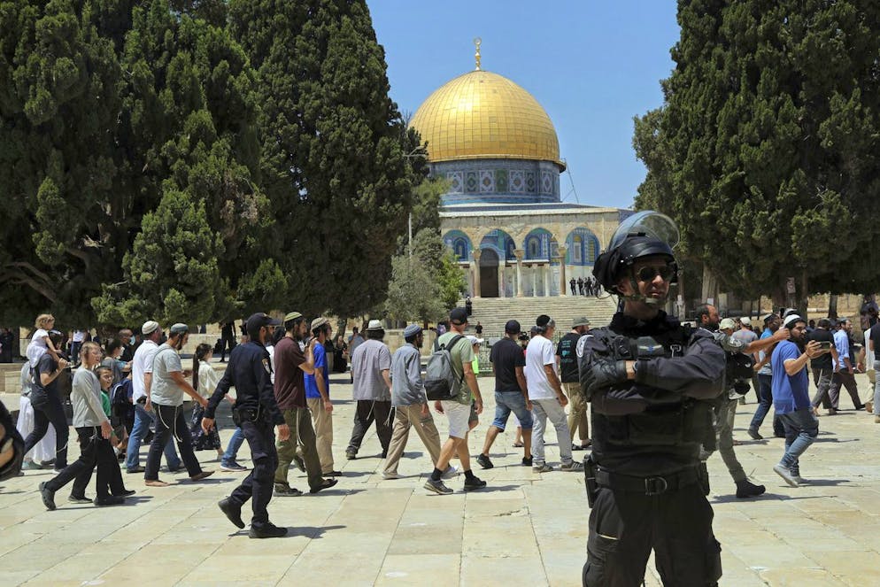 Dans cette photo d'archive du 18 juillet 2021, un officier de police israélien monte la garde alors que des hommes juifs visitent la mosquée du Dôme du Rocher dans l'enceinte de la mosquée Al Aqsa.
