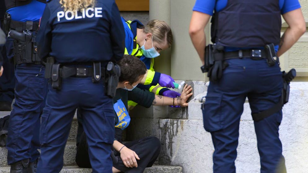 Eine Sanitäterin entfernt am 22. Juni die an das Bundeshaus geklebte Hand einer Exinction-Rebellion-Aktivistin in Bern.