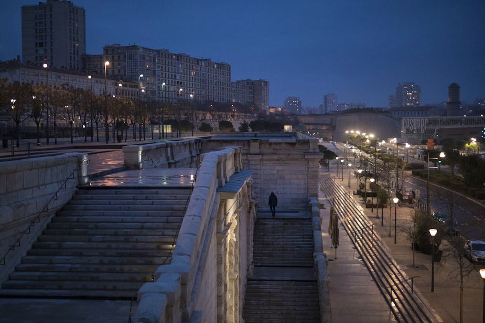 A man climbs an empty staircase as a curfew is enforced in Marseille, southern France, Sunday Jan. 10, 2021. The new curfew comes as French authorities are reinforcing the monitoring of sanitary containment measures in the light of new, potentially more contagious, variants of Covid19 in French territory. (AP Photo/Daniel Cole)