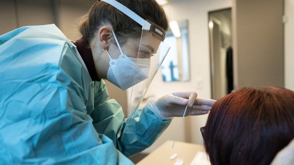 Eine Apothekerin in vorschriftsmaessiger Schutzkleidung macht bei einer Frau einen Abstrich fuer einen Covid-19 Antigen-Schnelltest in Apotheke TopPharm Apotheke am Paradeplatz am 3. November 2020 in Zuerich. (KEYSTONE/Gaetan Bally)