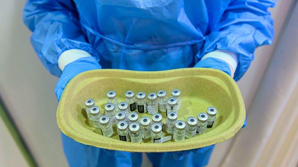11.01.2021, Sachsen, Dresden: Eine Mitarbeiterin im Impfzentrum in der Messe Dresden hält eine Schale mit leeren Injektionsfläschchen in den Händen, in denen sich Impfstoff gegen Corona von Biontech/Pfizer befand. Alle 13 sächsischen Impfzentren nehmen am heute ihren Betrieb auf. Foto: Robert Michael/dpa-Zentralbild/dpa +++ dpa-Bildfunk +++ (KEYSTONE/DPA/Robert Michael)
