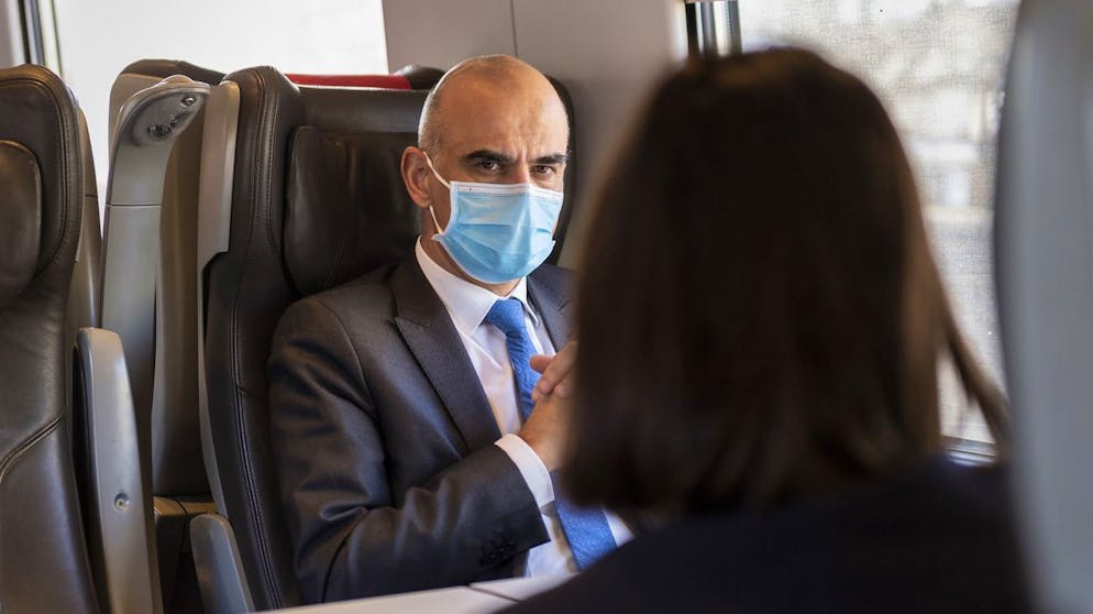 Bundesrat Alain Berset, links, diskutiert mit einer Mitarbeiterin im Zug nach nach Visp, am Montag, 11. Januar 2021 in Bern. Alain Berset wird mit einer Delegation das Schweizer Pharma und Biotech Unternehmen Lonza besuchen, das fuer das Biotech Unternehmen Moderna die Covid-19 Impfung herstellt. (KEYSTONE/Alessandro della Valle)