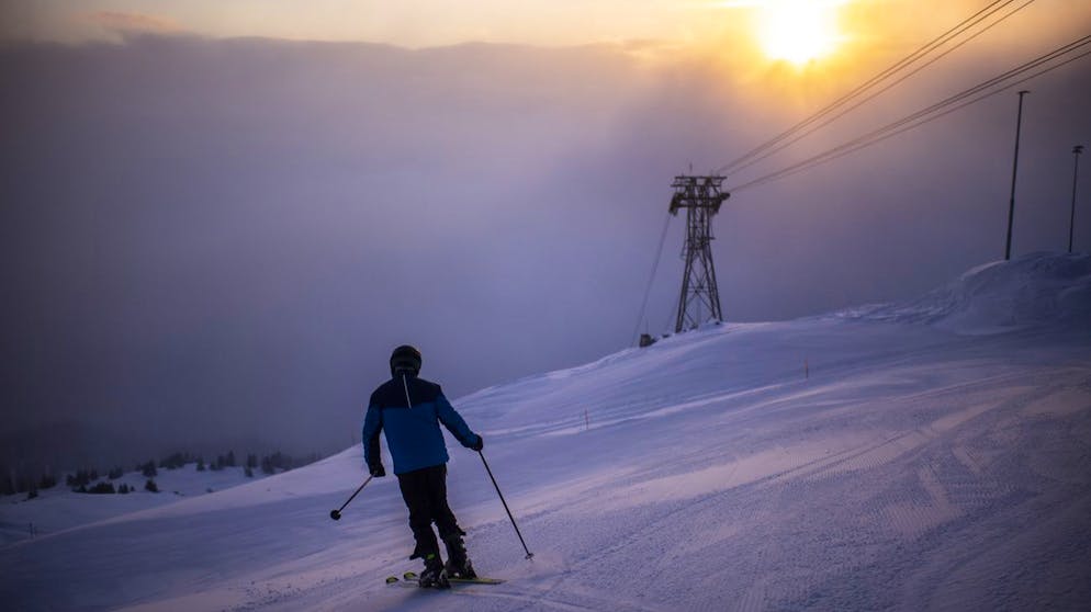 Skifahrer mit Schutzmaske, aufgenommen am Samstag, 26. Dezember 2020, im Skigebiet Flims Laax Falera, in Falera. Die Buendner Skigebiete bleiben trotz Coronavirus geoeffnet, allerdings mit reduzierter Transportkapazitaet. (KEYSTONE/Gian Ehrenzeller)