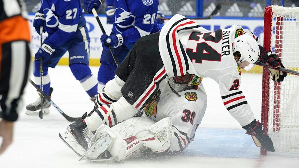 Chicago Blackhawks center Pius Suter (24) falls on goaltender Malcolm Subban (30) after a check by Tampa Bay Lightning center Blake Coleman (20) during the second period of an NHL hockey game Wednesday, Jan. 13, 2021, in Tampa, Fla. (AP Photo/Chris O'Meara)