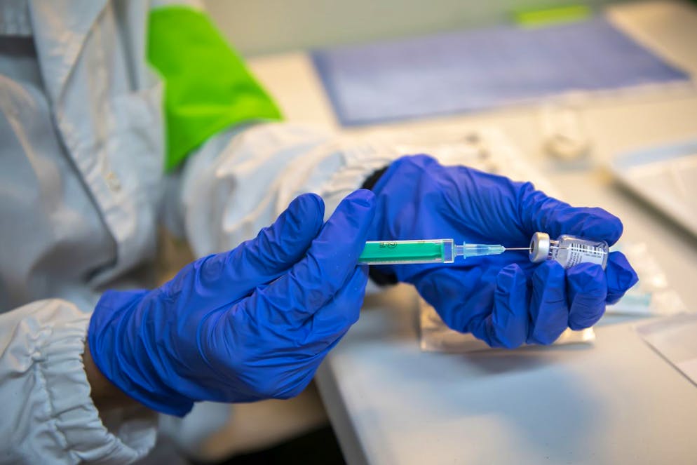 Une infirmiere prepare des seringues du vaccin Pfizer-BioNTech a coter du centre de vaccination, ce mercredi 6 janvier 2021 au centre m3 Sanitrade de vaccination a Geneve. Le canton de Geneve lance sa campagne de vaccination contre le Covid-19. La Confederation a mis a disposition des cantons un nombre de doses proportionnel a leur population. Les autorites sanitaires genevoises lancent des lors, en collaboration avec l?ensemble des acteurs de la sante, une campagne de vaccination historique, puisqu?aucune vaccination d?une telle ampleur n?a jamais ete menee dans le canton. (KEYSTONE/Martial Trezzini)