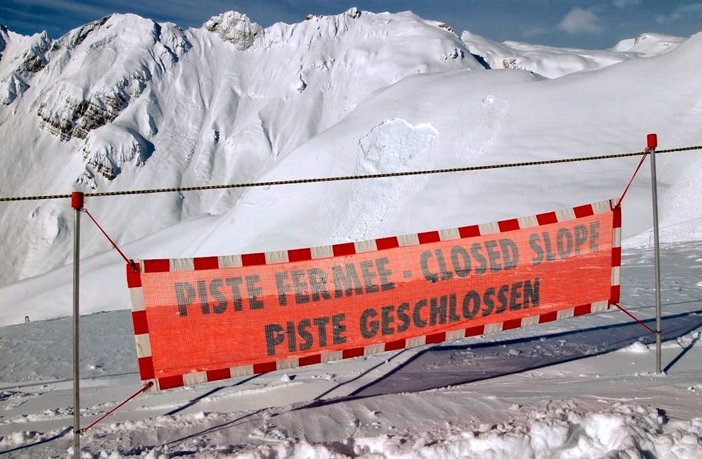 A banner indicates the closed skislope in the Skiing area of Anzere in the canton Wallis, Switzerland, Friday, Frebruary 7, 2003. The avalanche dangerlevel is high. (KEYSTONE/Andree-Noelle Pot)
