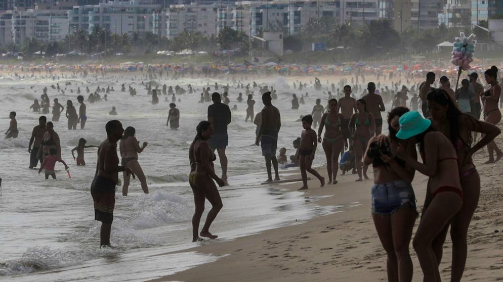 epa08929373 People spend time on the Barra de Tijuca beach, in the city of Rio de Janeiro, Brazil, 09 January 2021. Submerged in the second wave of the COVID-19 pandemic, Brazil is working against the clock to be able to start vaccination this month, a campaign that has been delayed and has become a prelude to the Presidential elections in 2022. EPA/Antonio Lacerda