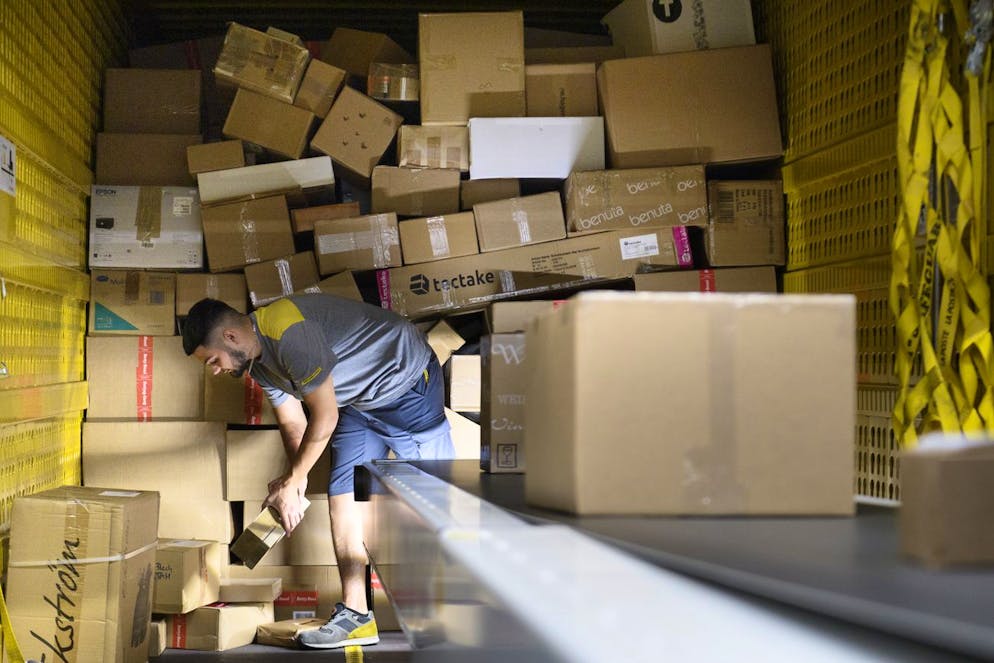 Un employe de la poste trie des paquets dans le nouveau centre regional de tri des colis de la Poste ce lundi 14 septembre 2020 a Vetroz. (KEYSTONE/Laurent Gillieron)