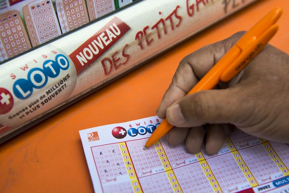 Une personne remplie un billet de loterie