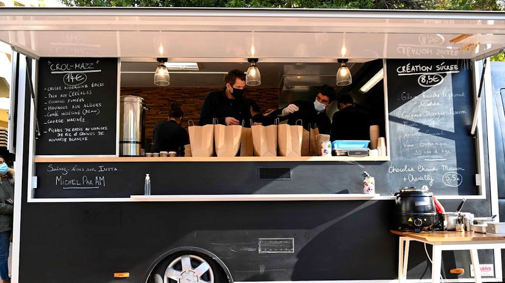 French chef Alexandre Mazzia (L) and his team prepare takeaway meals in a food-truck in Marseille, southern France, on November 24, 2020. - Mazzia, who was appointed