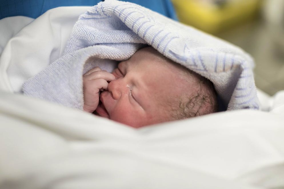 A new father holds his newborn infant named Julia, pictured at the maternity unit of the Triemli Hospital in Zurich, Switzerland, on September 27, 2016. Julia was delivered by cesarean section because she was facing the wrong way for a vaginal delivery. (KEYSTONE/Gaetan Bally)