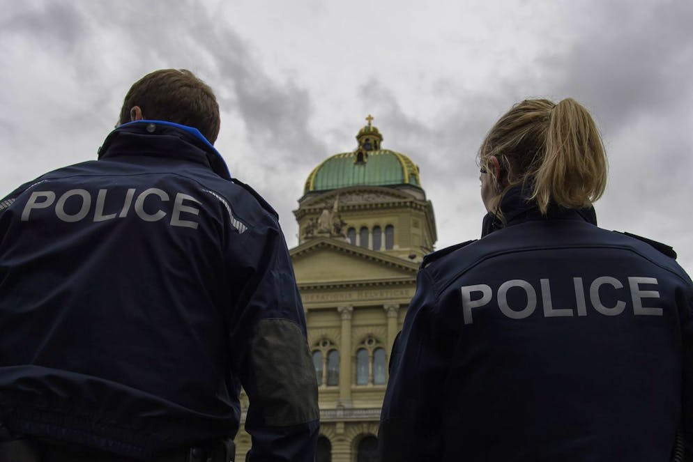 Two Police officers in front of the Swiss Federal Palaceat at a protest against the Coronavirus lockdown in Bern, Switzerland, 23 May 2020. In Switzerland from 11 May, loosening measures slowing down the ongoing pandemic of the COVID-19 disease, which is caused by the SARS-CoV-2 coronavirus, become effective by step. (KEYSTONE/Anthony Anex)