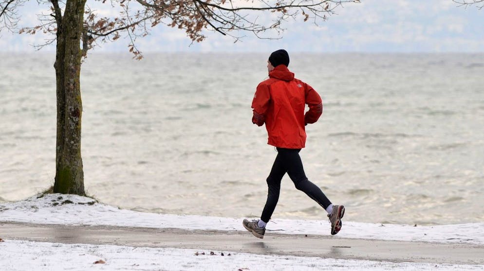A man runs in the cold at the border of the Geneva Lake in Lausanne