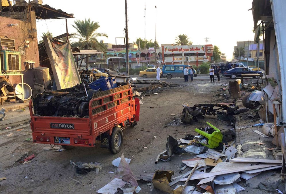 Civilians inspect the aftermath of a car bomb explosion in the morning in Baghdad's eastern neighborhood of Baladiyat, Iraq, Saturday, Oct. 18, 2014. The car bomb exploded after nightfall Friday, near a cafe, killed and wounded tens of people, Iraqi officials said. (AP Photo/Khalid Mohammed)