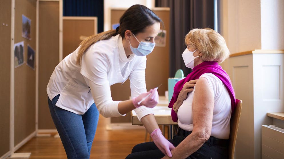 Ein Frau wird geimpft mit dem Impfstoff von Pfizer Biontech gegen das Coronavirus, aufgenommen am Montag, 18. Januar 2021, bei einem Rundgang im kantonalen Impfzentrum in Ennenda. (KEYSTONE/Gian Ehrenzeller)