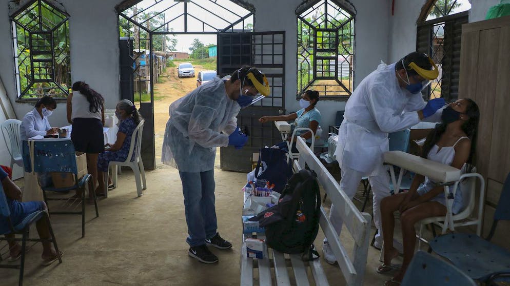 Health workers test people for COVID-19 at the Indigenous Park, a tribal community in the outskirts of Manaus, Amazonas state, Brazil, Thursday, Jan. 7, 2021. Medical teams are scrambling to assist indigenous people living in outlying areas of Manaus, where medical care is scarce after authorities issued a "State of Emergency" due to rising numbers of infection numbers in Amazonas State. (AP Photo/Edmar Barros)