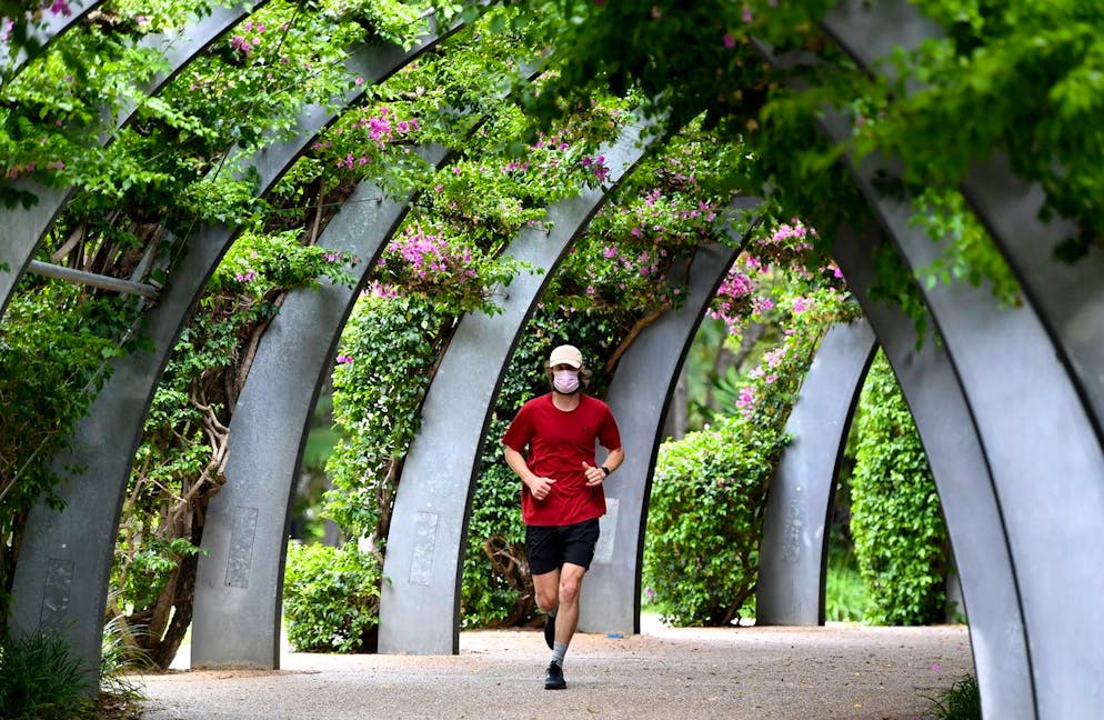 epa08927438 A man is seen jogging at South Bank in Brisbane, Australia, 09 January 2021. Residents of Greater Brisbane face mandatory lockdown over the weekend in a bid to contain the highly contagious UK variant of COVID-19. EPA/DARREN ENGLAND AUSTRALIA AND NEW ZEALAND OUT